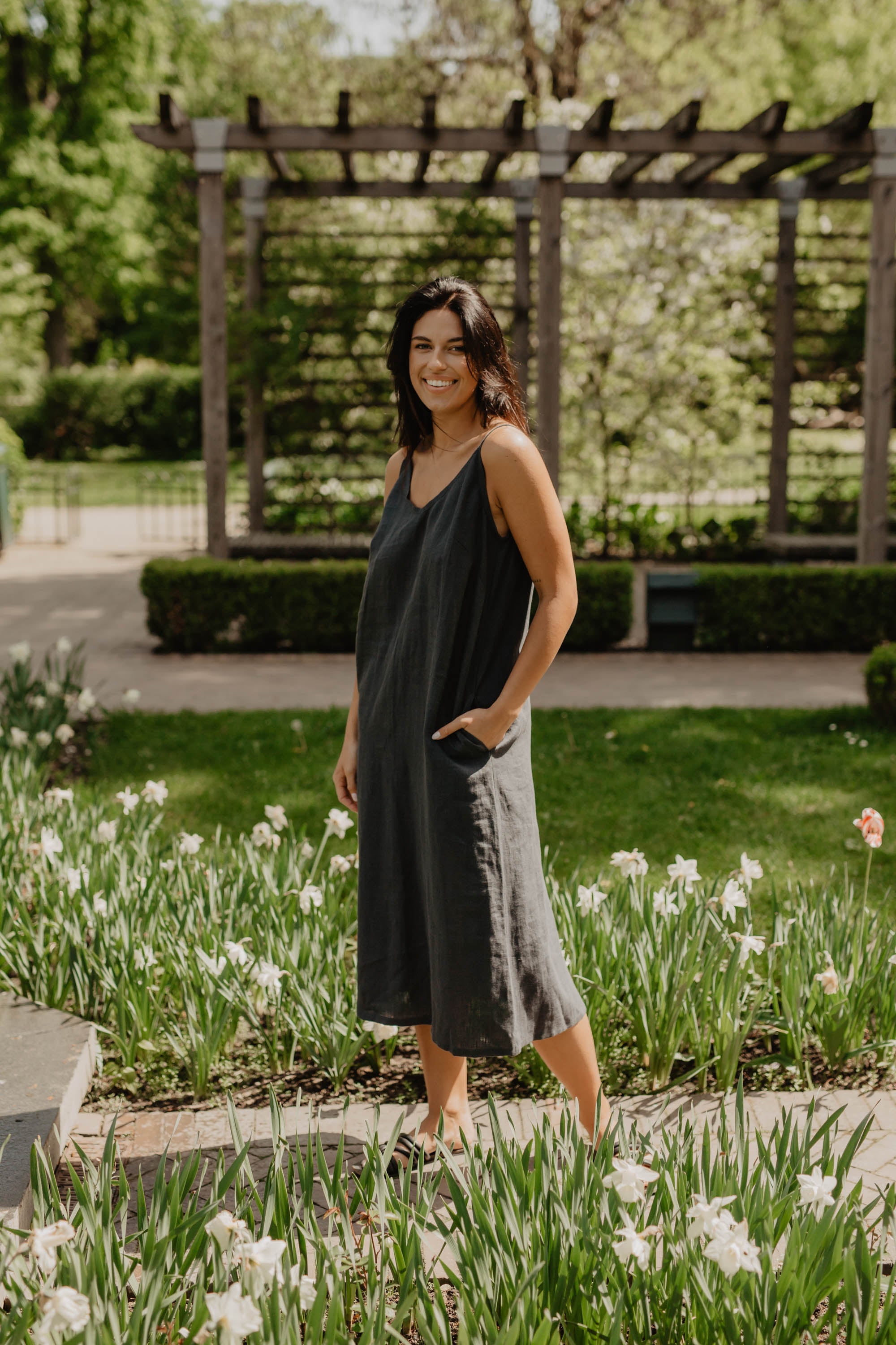 Woman Wearing A Long Dark Linen Dress By AmourLinen In A Park