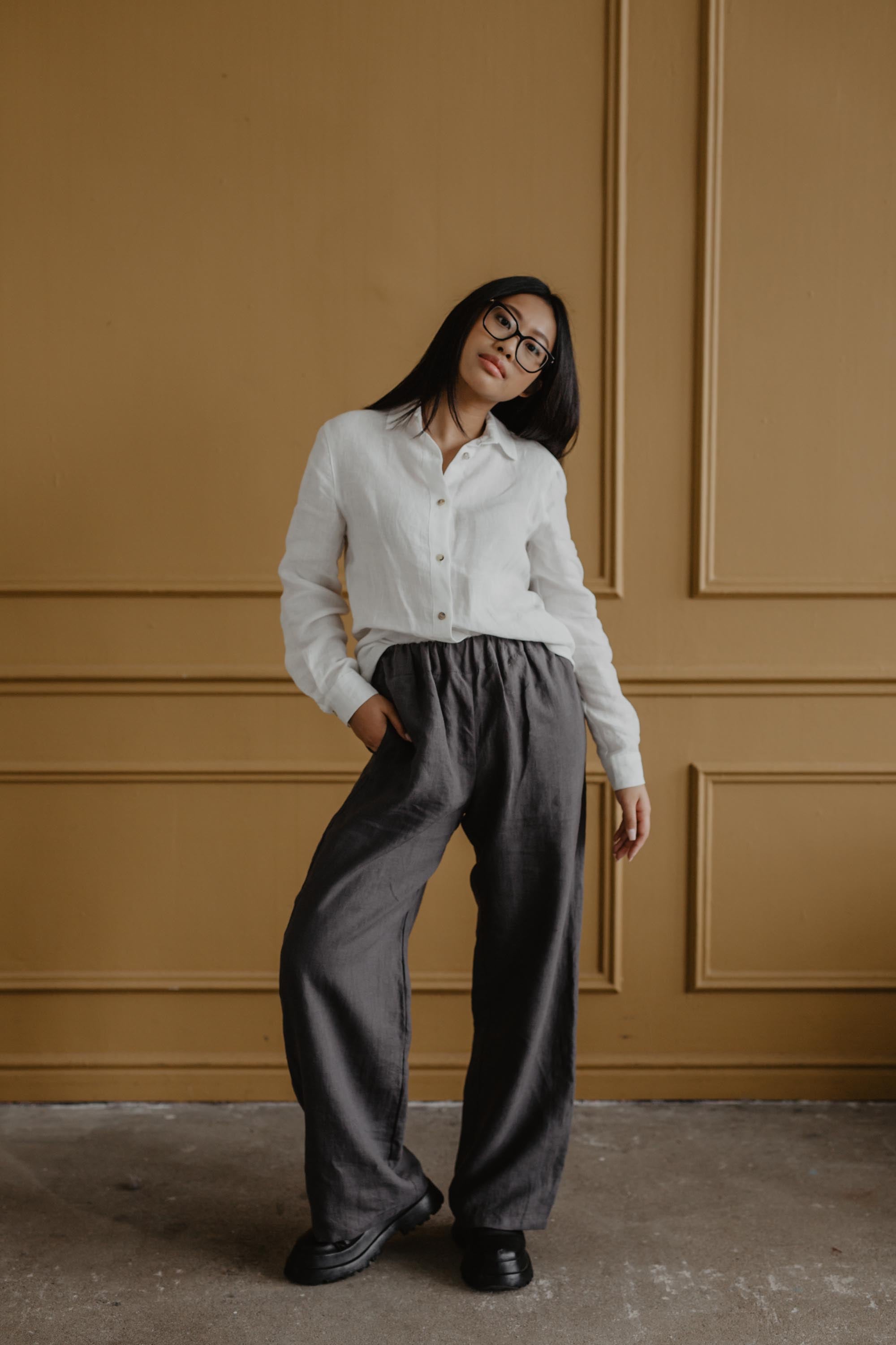 Woman Wearing Super Long Grey Linen Pants and White Linen Shirt Posing