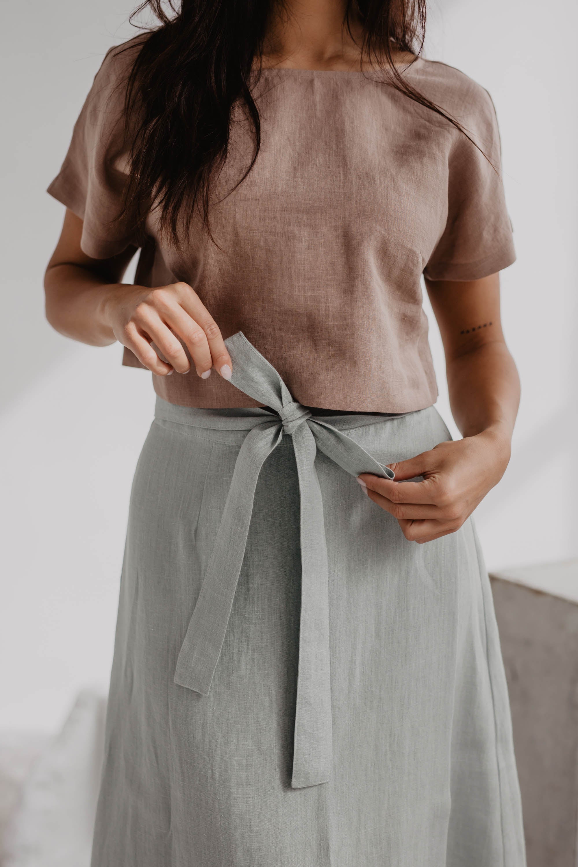 Woman Facing Forward Close Up Of Dusty Rose Linen Crop Top and Sage Green Linen Skirt
