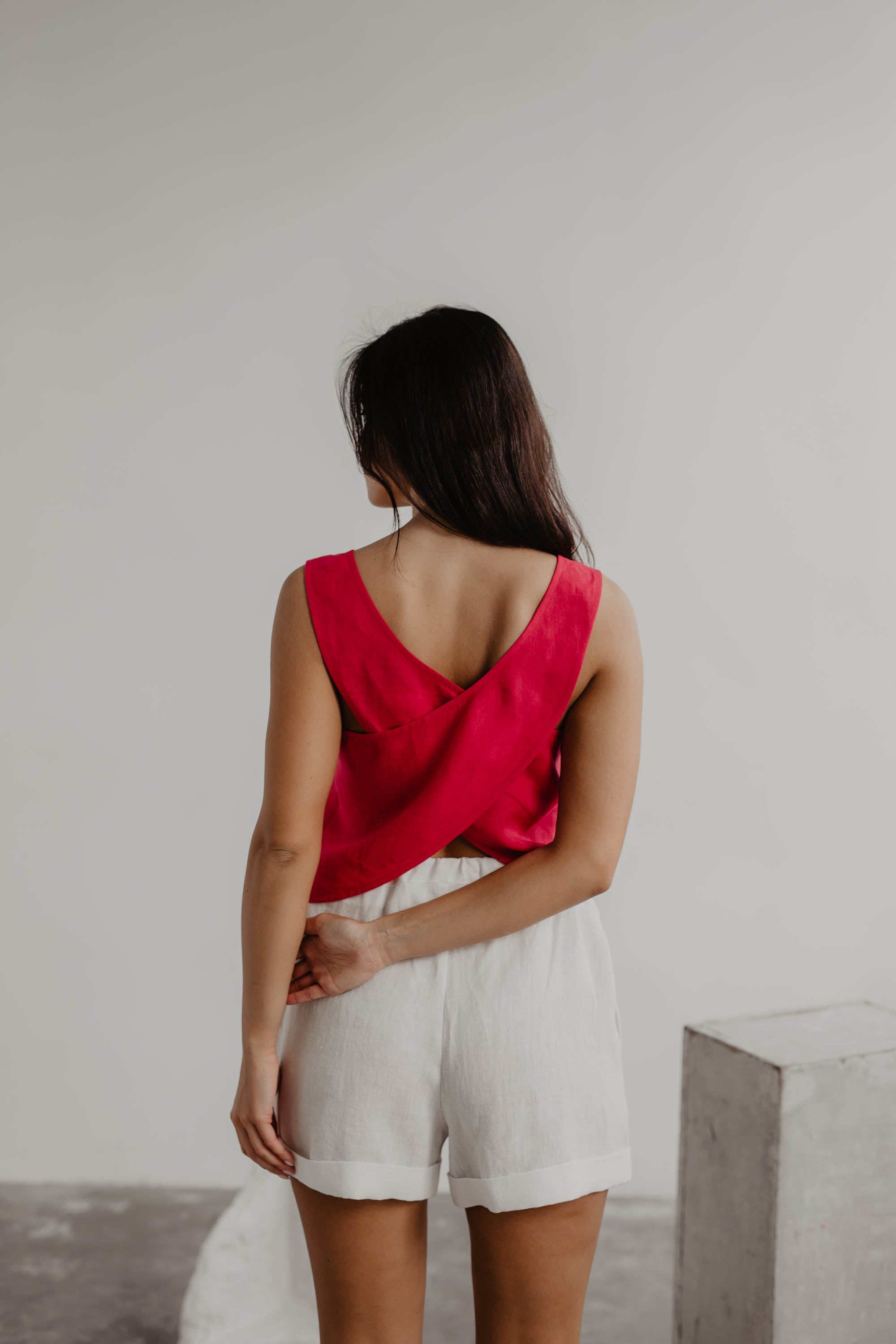 Back Of A Woman Wearing A Magenta Linen Top and White Linen Shorts