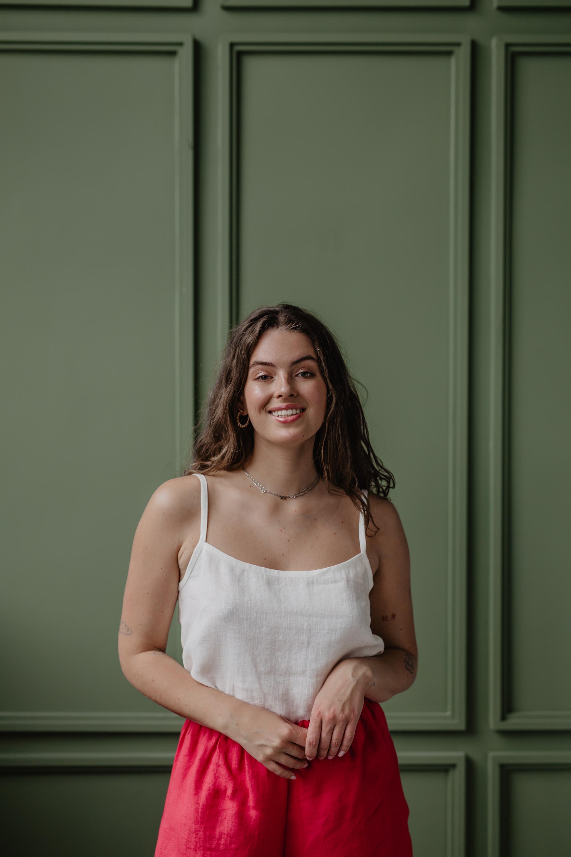 Close Up Of Woman Wearing A White Linen Top and Magenta Linen Pants By Amourlinen