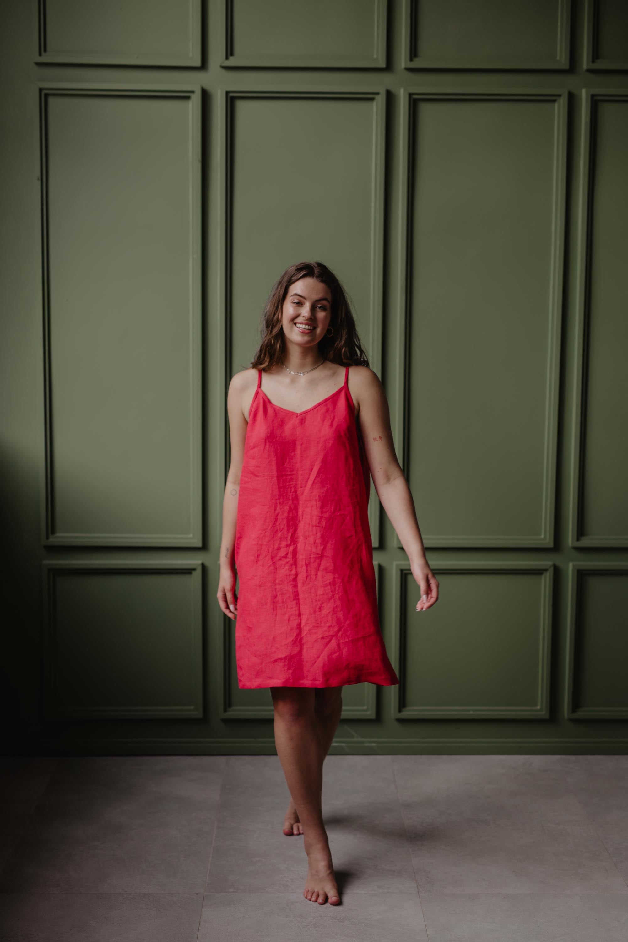 Women Wearing A Red Linen Slip Dress In Green Room by Amourlinen