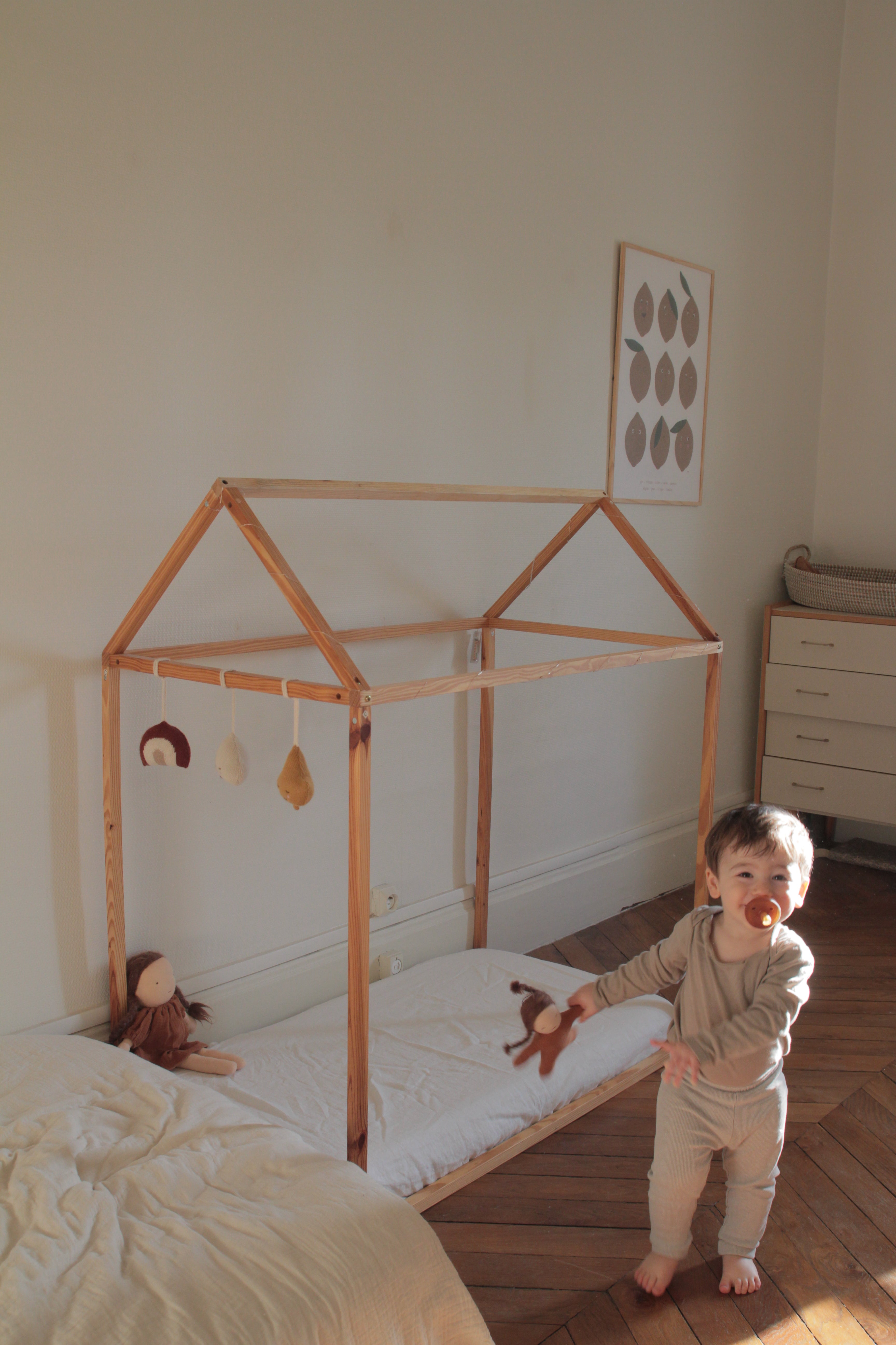 Baby Standing next to Bed With White Linen Crib Sheet By Amourlinen